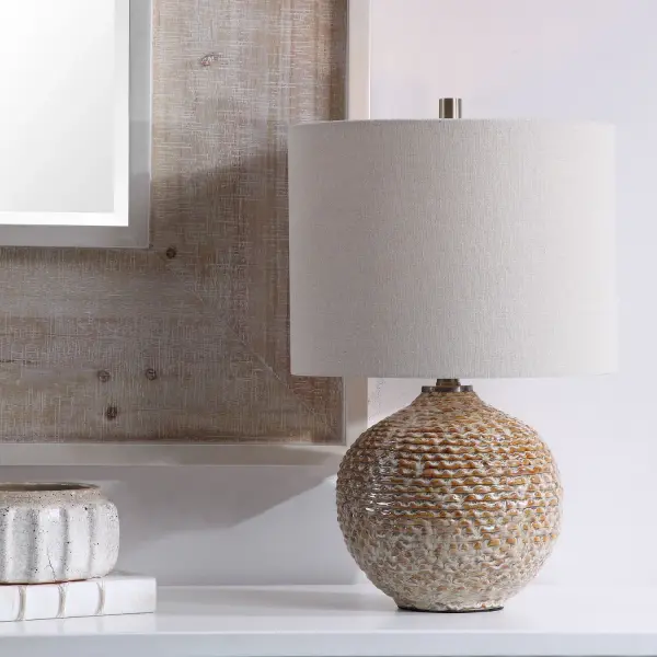 This Unique Ceramic Table Lamp Displays A Rustic, Wavy Ribbed Texture In Rust Brown Glaze Covered In Aged Taupe Tones, Accented With Light Brushed Brass Details. The Hardback Drum Shade Is Light Beige Linen With Natural Slubbing. Collection: Lagos Designer: David Frisch Finish: Brushed Brass Glass: Round Drum Hardback Shade Width: 14.00" Height: 22.00" Length: 14.00" Weight: 6.00 lb Number of Bulbs: 1 Maximum Wattage: 150.00 W Bulb Type: A Voltage: 110.00 V Material: Ceramic & Metal & Fabric Country of Origin: Cambodia Safety Rating: Indoor Only Switch: 3-WAY
