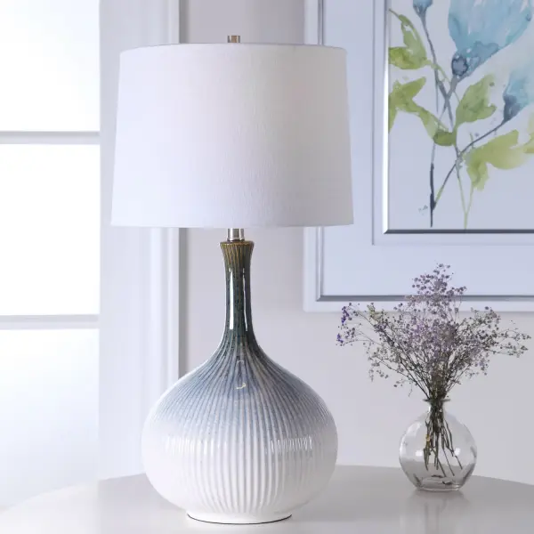 Mid-century Inspired Table Lamp Has A Fluted Ceramic Base With Noticeable Ribbed Texture And Is Finished In A Cream, Light Blue, Indigo, And Dark Brown Ombre Glaze With Brushed Nickel Plated Accents. The Lamp Is Paired With A Tapered Round Hardback Shade In An Off-white Linen Fabric With Light Slubbing. Collection: Eichler Finish: Brushed Nickel Glass: Round Hardback Width: 14.00" Height: 28.00" Length: 14.00" Weight: 9.00 lb Number of Bulbs: 1 Maximum Wattage: 150.00 W Bulb Type: A Voltage: 110.00 V Material: Ceramic, Fabric, Iron Country of Origin: China Safety Rating: Indoor Only Switch: 3-WAY
