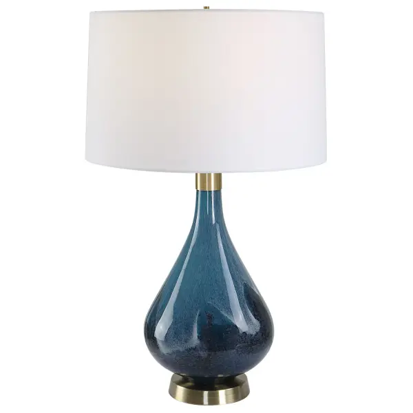 Crafted From Art Glass, This Table Lamp Features A Beautiful Blend Of Rich Sapphire And Dark Navy Blue Accented By Plated Antique Brass Finished Details. The Slightly Tapered Hardback Shade Is Covered In A White Linen Fabric. Collection: Riviera Designer: David Frisch Finish: Antique Brass Glass: Round Hardback Shade Width: 17.00" Height: 27.75" Length: 17.00" Weight: 9.40 lb Number of Bulbs: 1 Maximum Wattage: 150.00 W Bulb Type: A Voltage: 110.00 V Material: Steel , Glass , Fabric Country of Origin: China Safety Rating: Indoor Only