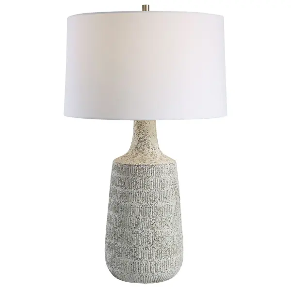 Drawing Inspiration From Antique Clay Pottery, This Table Lamp Is Handcrafted From Ceramic In A Mottled Gray And Off-white Matte Glaze With Subtle Carved Details. Steel Accents Are Finished In Brushed Nickel. The Hardback Drum Shade Is Covered In A Casual White Fabric. Collection: Scouts Designer: Carolyn Kinder Finish: Brushed Nickel Glass: Round Hardback Shade Width: 17.00" Height: 28.50" Length: 17.00" Weight: 8.00 lb Number of Bulbs: 1 Maximum Wattage: 150.00 W Bulb Type: A Voltage: 110.00 V Material: Steel, Ceramic, Fabric Country of Origin: China Safety Rating: Indoor Only