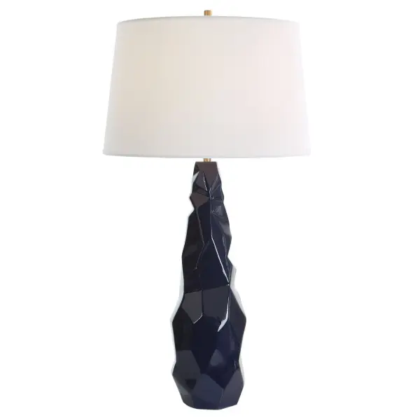 This Ceramic Table Lamp Showcases A Contemporary Abstract Geometric Design Finished In A Striking Navy Blue Gloss Glaze With Plated Brushed Brass Details. Paired With A Tapered Hardback Shade In A White Linen Fabric. Collection: Kavos Designer: Carolyn Kinder Finish: Brushed Brass Glass: Rectangle Hardback Width: 16.00" Height: 31.00" Length: 16.00" Weight: 8.00 lb Number of Bulbs: 1 Maximum Wattage: 150.00 W Bulb Type: A Voltage: 110.00 V Material: Ceramic, Iron, Fabric Country of Origin: China Safety Rating: Indoor Only