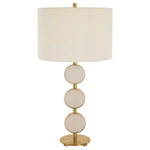 This Table Lamp Brings A Soft Contemporary Flair To Any Room By Featuring Three Suspended Alabaster Disk Surrounded By A Sleek Metal Base Finished In A Plated Brushed Brass. The Round Hardback Shade Is Covered In A Crisp White Linen Fabric. Collection: Three Rings Finish: Brushed Brass Glass: Round Hardback Shade Width: 14.50" Height: 28.50" Length: 14.50" Weight: 8.00 lb Number of Bulbs: 1 Maximum Wattage: 150.00 W Bulb Type: A Voltage: 110.00 V Material: Metal, Alabaster, Fabric Country of Origin: Cambodia Safety Rating: Indoor Only