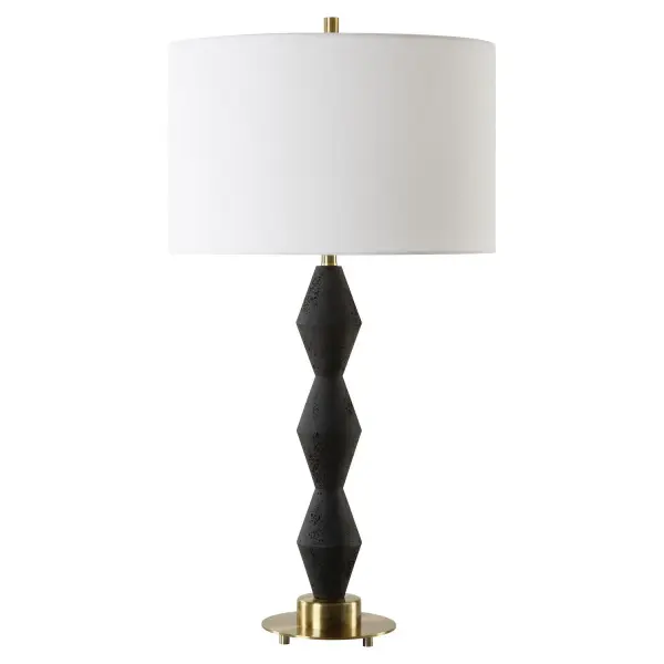 This Table Lamp Is Crafted From Cast Black Man-made Stone For A Bold Yet Refined Aesthetic. Its Distinctive Pitted Surface Adds Character And Texture, Complemented By Antique Brass Plated Details For A Touch Of Vintage Allure. The Round Hardback Drum Shade Is A Crisp White Linen Fabric. Collection: Threefold Designer: David Frisch Finish: Antique Brass Glass: Round Drum Hardback Shade Width: 16.00" Height: 29.75" Length: 16.00" Weight: 7.70 lb Number of Bulbs: 1 Maximum Wattage: 150.00 W Bulb Type: A Voltage: 110.00 V Material: Steel , Rice Stone Resin, Fabric Country of Origin: China Safety Rating: Indoor Only