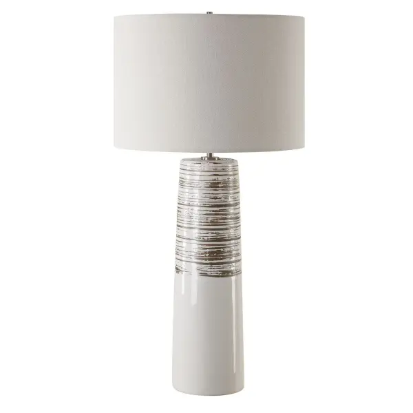The Haven Table Lamp Combines Elegance With A Touch Of Rustic Charm. This Piece Features A Sleek Ceramic Base Cloaked In A Smooth White Glaze, Adorned With Subtly Ribbed, Distressed Accents, All Complemented By Brushed Plated Nickel Hardware For A Refined Finish. The Round Hardback Drum Shade Is Made In A Casual White Linen Fabric. Collection: Haven Designer: Osvaldo Mendoza Finish: Brushed Plated Nickel Glass: Round Drum Hardback Shade Width: 15.00" Height: 29.50" Length: 15.00" Weight: 7.00 lb Number of Bulbs: 1 Maximum Wattage: 150.00 W Bulb Type: A Voltage: 110.00 V Material: Steel, Ceramic, Fabric Country of Origin: China Safety Rating: Indoor Only