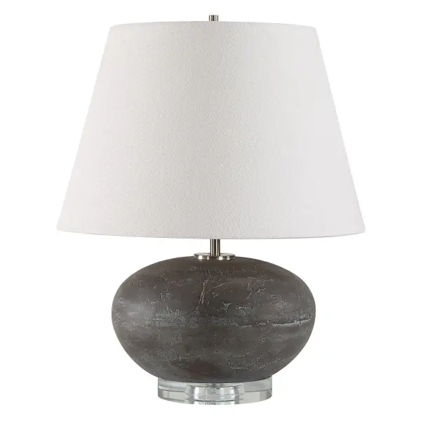 Featuring A Ceramic Base Finished In A Distressed Charcoal Glaze With Unique Stone-like Texture And Bronze Highlights. The Beckley Table Lamp Is Elegantly Accented With A Thick Crystal Foot And Plated Nickel Hardware. The Tapered Round Hardback Shade Is Covered In A Casual White Linen Fabric. Collection: Beckley Designer: Osvaldo Mendoza Finish: Plated Nickel Glass: Round Hardback Shade Width: 15.00" Height: 18.75" Length: 15.00" Weight: 11.00 lb Number of Bulbs: 1 Maximum Wattage: 150.00 W Bulb Type: A Voltage: 110.00 V Material: Steel, Crystal, Ceramic, Fabric Country of Origin: China Safety Rating: Indoor Only