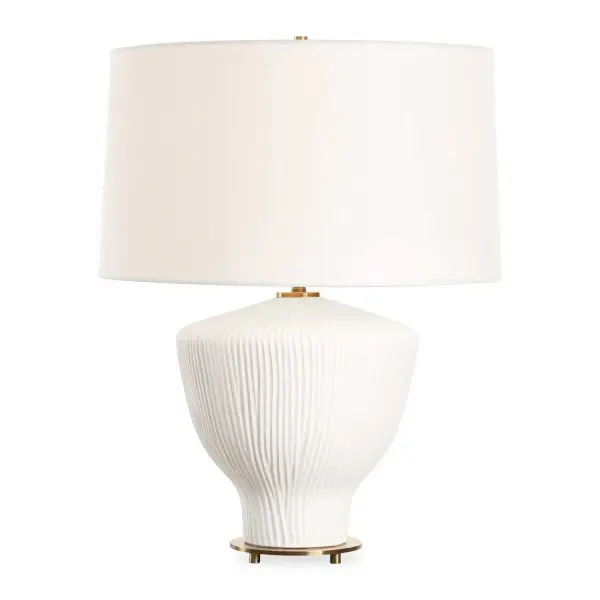 The Maisie Table Lamp Is A Classic Yet Timeless Piece That Features A Unique Ceramic Base With A Vertical Ribbed Texture Finished A Satin White Accented With Brass Plated Details. The Slightly Tapered Round Hardback Shade Is Covered In A White Linen Fabric. Collection: Maisie Designer: Jim Parsons Finish: Satin White Accented With Brass Plated Glass: Round Hardback Rolled Edge Width: 18.00" Height: 23.50" Length: 18.00" Weight: 9.90 lb Number of Bulbs: 1 Maximum Wattage: 150.00 W Bulb Type: A Voltage: 110.00 V Material: Ceramic Country of Origin: China Safety Rating: Indoor Only