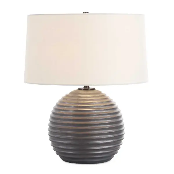 The Chelsom Table Lamp Features A Ribbed Ceramic Base Finished In A Satin Dark Bronze Glaze Accented With Matching Dark Bronze Hardware. A White Linen Round Hardback Shade Completes The Piece. Collection: Chelsom Designer: Carolyn Kinder Finish: Dark Bronze Glass: Round Hardback Shade Width: 18.00" Height: 22.00" Length: 18.00" Weight: 8.00 lb Number of Bulbs: 1 Maximum Wattage: 150.00 W Bulb Type: A Voltage: 110.00 V Material: Metal, Ceramic, Fabric Country of Origin: Vietnam Safety Rating: Indoor Only