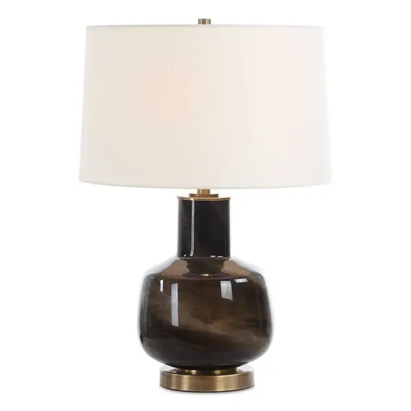 The Buchanan Table Lamp Showcases A Smokey Charcoal Glass, Accented With Plated Brass Details That Conveys A Sense Of Opulence. The Slightly Tapered Round Hardback Shade Is Covered In A White Linen Fabric. Collection: Buchanan Designer: Carolyn Kinder Finish: Brass Glass: Round Hardback Shade Width: 16.00" Height: 23.50" Length: 16.00" Weight: 8.00 lb Number of Bulbs: 1 Maximum Wattage: 150.00 W Bulb Type: A Voltage: 110.00 V Material: Metal, Glass, Fabric Country of Origin: China Safety Rating: Indoor Only