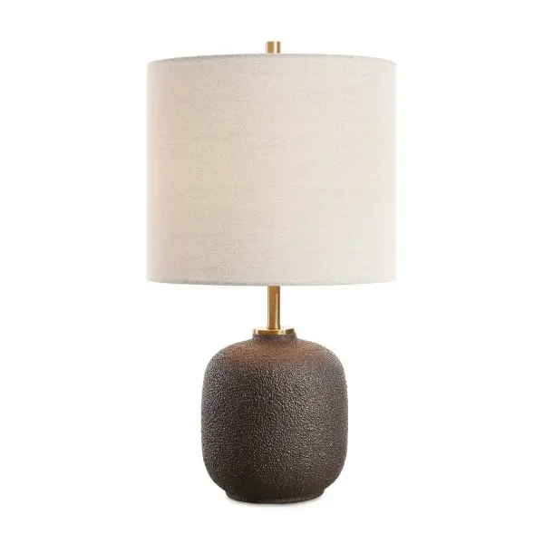 This Ceramic Base Features A Heavy Textured Surface Finished In A Warm Black, Accented With A Plated Antique Brass Details. The Round Hardback Drum Shade Is A Casual Light Gray Linen Fabric. Collection: Blacktop Finish: Antique Brass Glass: Drum Hardback Rolled Edge, With White Fabric Liner Inside Width: 12.00" Height: 21.50" Length: 12.00" Weight: 4.85 lb Number of Bulbs: 1 Maximum Wattage: 150.00 W Bulb Type: A Voltage: 110.00 V Material: Steel, Ceramic, Fabric Country of Origin: China Safety Rating: Indoor Only