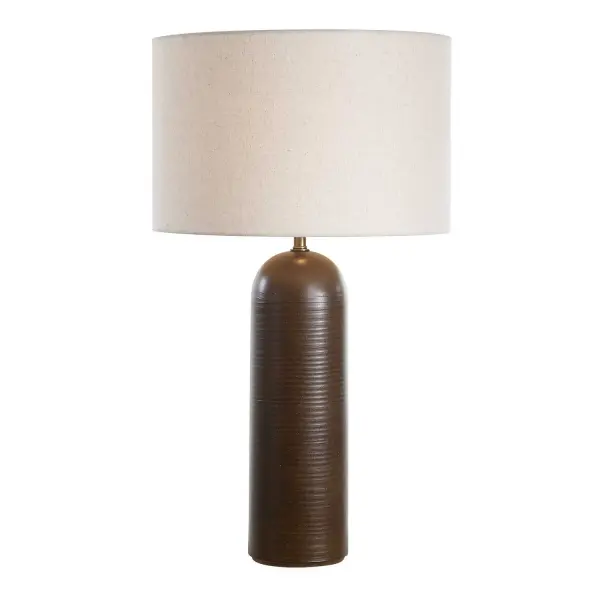 The Trexler Table Lamp Features A Ceramic Base That's Finished In A Rich Cocoa Brown That Exudes Warmth And Sophistication. The Base Features A Subtle Texture Over Horizontal Ridges, Paired With Brass Plated Details. The Round Hardback Drum Shade Is An Oatmeal Linen Fabric With Natural Slubbing. Collection: Trexler Designer: David Frisch Finish: Brass Glass: Round Drum Hardback Shade Width: 17.00" Height: 29.50" Length: 17.00" Weight: 10.80 lb Number of Bulbs: 1 Maximum Wattage: 150.00 W Bulb Type: A Voltage: 110.00 V Material: Metal & Ceramic & Linen Country of Origin: China Safety Rating: Indoor Only