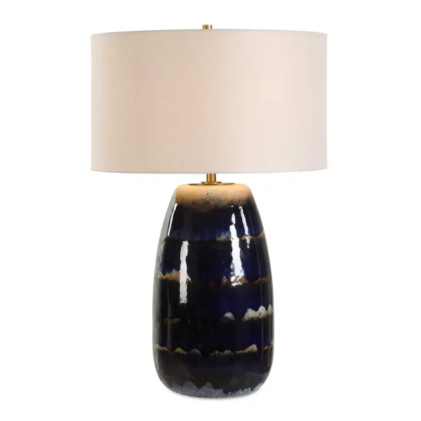 The Orleans Table Lamp Combines A Heavy Blue Drip Glaze Over Tones Of Rust Brown Warm Ivory, Paired With Antique Brass Accents, Creating A Distinctive, Artisan-inspired Design. The Round Hardback Drum Shade Is Covered In A White Linen Fabric. Due To The Nature Of Fired Glazes On Ceramic Lamps, Finishes Will Vary Slightly. Collection: Orleans Designer: Matthew Williams Finish: Antique Brass Glass: Round Hardback Shade Width: 18.00" Height: 27.50" Length: 18.00" Weight: 10.49 lb Number of Bulbs: 1 Maximum Wattage: 150.00 W Bulb Type: A Voltage: 110.00 V Material: Ceramic , Metal, Fabric Country of Origin: China Safety Rating: Indoor Only