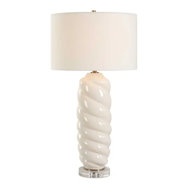The Anneli Table Lamp Features A Gloss White Ceramic Base In A Tapered Swirl Design For A Timeless Coastal Appeal. The Addition Of A Crystal Foot And Antique Brass Plated Details Creates A Truly Unique And Eye-catching Look. The Round Hardback Shade Is Covered In A Crisp White Linen Fabric. Collection: Anneli Designer: Renee Wightman Finish: Antique Brass Plated Glass: Round Drum Hardback Width: 16.00" Height: 30.50" Length: 16.00" Weight: 9.26 lb Number of Bulbs: 1 Maximum Wattage: 150.00 W Bulb Type: A Voltage: 110.00 V Material: Ceramic, Crystal, Iron, Fabric Country of Origin: China Safety Rating: Indoor Only