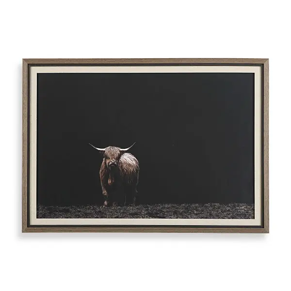 A striking framed photograph of a highland cow against black, wrapped in a distressed wood-tone frame — a simple way to add rustic drama to a room.