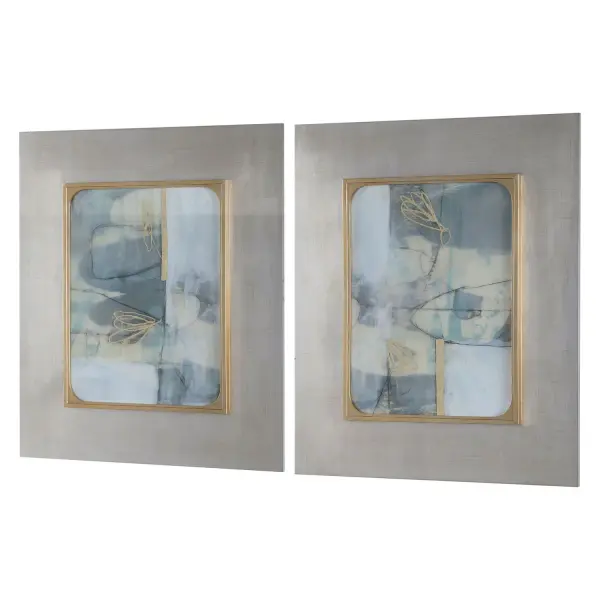 This set of two abstract prints combines soft powder blue, charcoal, and gold tones with substantial silver leaf frames, offering a refined decorative accent for walls needing artistic character.