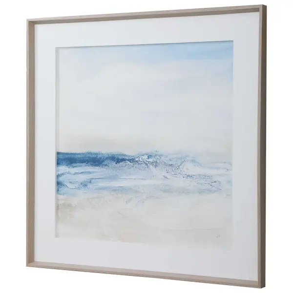 A large-scale coastal print in cobalt blue, white, and sand tones, framed in natural pine with a white inner mat—an easy way to anchor a beach-inspired room.