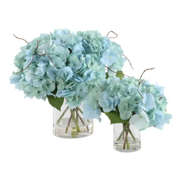 A set of two faux blue hydrangea arrangements in glass vases with faux water and twigs—low-maintenance decor with a serene, coastal feel.