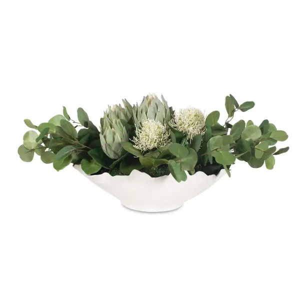 A textured ceramic bowl filled with lifelike white protea blooms and eucalyptus stems brings organic texture to tables and consoles without upkeep.