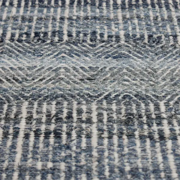A hand-woven birds-eye pattern rug blending natural wool with rescued denim for a textured, sustainable statement piece in blue.