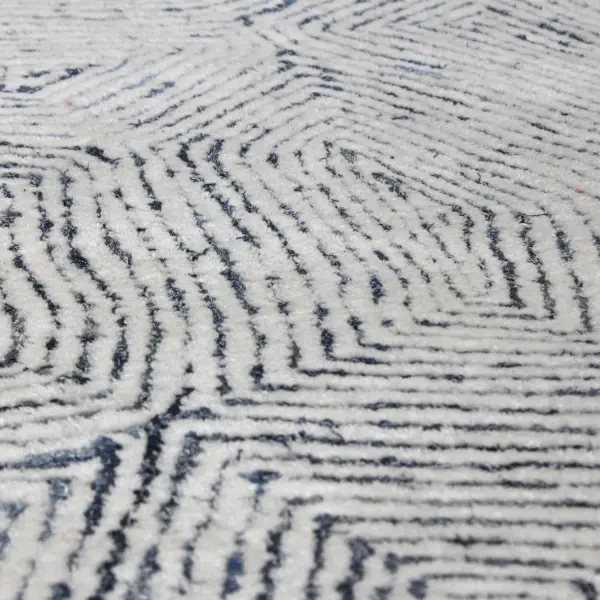 A hand-tufted area rug pairing ivory wool with rescued denim for a plush, textured cut pile in a soft blue palette. Eco-conscious and tactile.