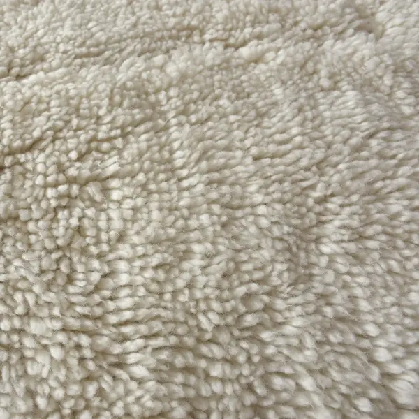 A cozy, tufted New Zealand wool shag rug in ivory with a subtle organic cutout pattern—soft underfoot and easy to style in neutral interiors.