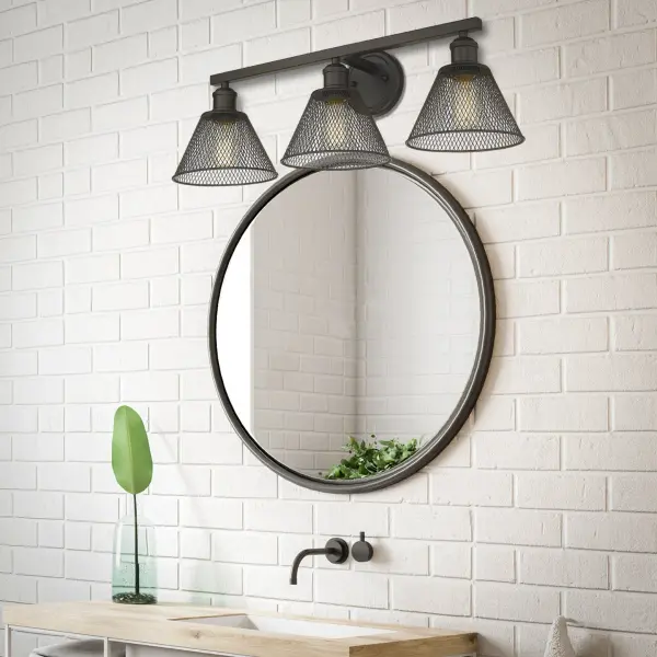 The Carver 3-Light Vanity combines industrial design with modern elegance, featuring a distinctive metal mesh shade and rich rubbed bronze finish. Perfect for bathrooms and damp locations, it provides warm, inviting illumination. - alternate view