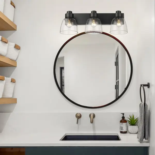 The Golden Lighting Remy 3-Light Vanity combines sleek sophistication with functional design. Its matte black frame and clear glass shades deliver brilliant, unobstructed illumination perfect for bathrooms and damp locations. - alternate view
