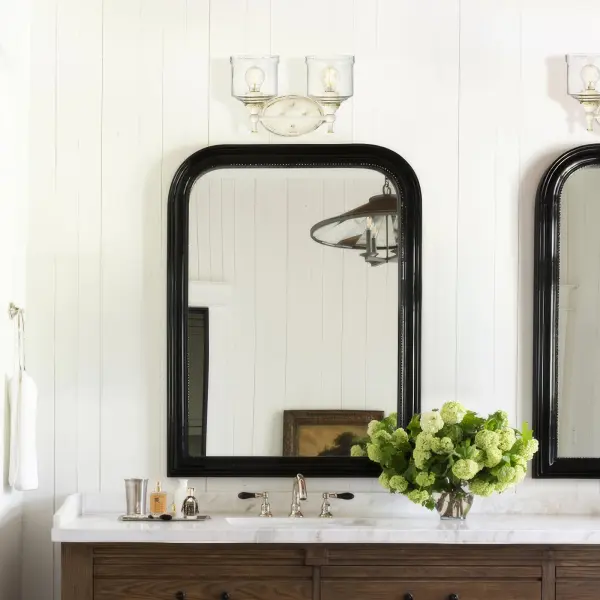 The Keating 2-Light Vanity brings warmth and character to bathrooms with its antique ivory finish and hammered water glass shades. The textured finish reveals a gilded underlayer, creating timeless farmhouse charm with practical functionality. - alternate view