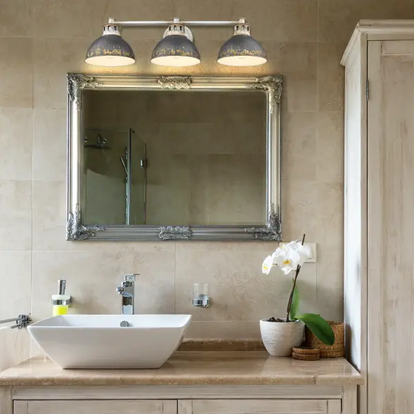 The Kinsley 3-light vanity brings industrial elegance to bathrooms with its distressed matte charcoal-black finish that simulates authentic weathered iron. Each piece features unique patina variations for distinctive character. - alternate view