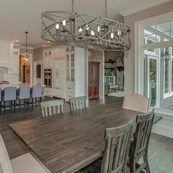 The Alcott 8-Light Island Light combines vintage farmhouse charm with industrial elegance. Its hand-painted Antique Black Iron finish and open-cage design create dramatic visual impact while providing ample illumination for large kitchen islands and dining tables. - alternate view