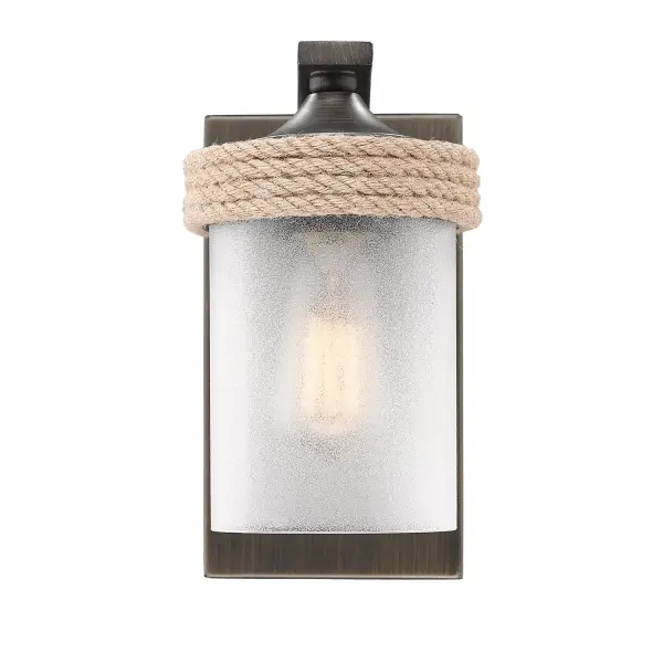 Illuminate your bathroom with the coastal-inspired Wry Lighting Chatham 1-light Vanity in Gunmetal Bronze. This elegant piece blends traditional design with the beauty of natural elements. Featuring a clear sandblasted glass shade, it offers soft and diffused illumination, creating a serene ambiance. The artisanal glass diffuses light beautifully, reminiscent of sea glass, enhancing your space's tranquility. The Gunmetal Bronze finish is a richly layered metallic which effectively marries warmth with an industrial edge. Its texture and character create a handsome profile, making it an exquisite addition to any bathroom decor. Damp location rated, this vanity light is suitable for covered and semi-enclosed spaces such as bathrooms and laundry rooms. Requires just one E26 medium base bulb (not included) with a max wattage of 100. The overall dimensions are 4.88"W x 8.63"H x 7.88"D, ensuring a compact yet impactful design. Enhance your bathroom's aesthetic with this artisan piece from Wry Lighting, designed for both function and style. - alternate view