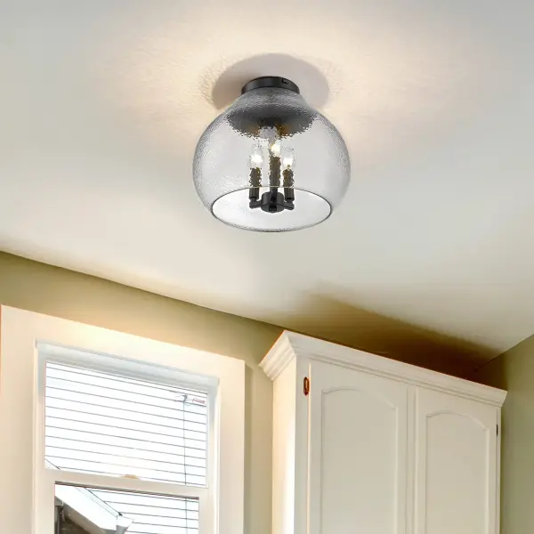 The Ariella flush mount combines hammered clear glass with a sleek matte black finish to deliver sparkling light effects in compact spaces. Damp-rated and ideal for low ceilings, it brings modern sophistication to hallways, bathrooms, and utility areas. - alternate view