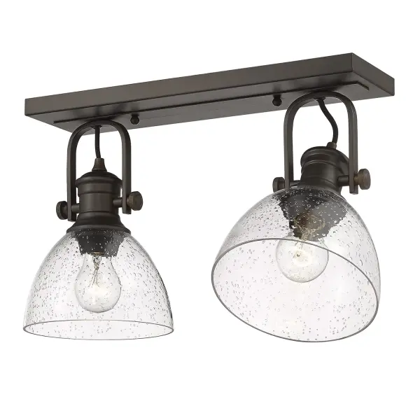 The Hines Semi-Flush Mount combines vintage-inspired seeded glass with warm rubbed bronze finish, creating an inviting ambiance. Adjustable directional heads offer customizable lighting, while damp location rating ensures versatility.