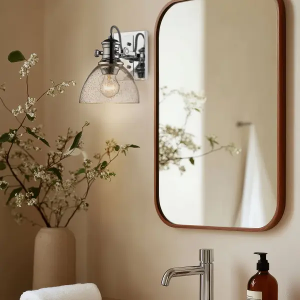 The Hines vanity light combines farmhouse elegance with practical functionality. Its seeded glass shade creates warm, inviting ambiance while the polished chrome finish adds timeless sophistication to any bathroom. - alternate view