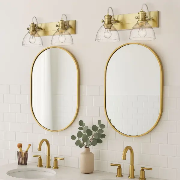 The Hines 2-Light Vanity combines artisanal seeded glass with sophisticated Brushed Champagne Brass for a warm, vintage-inspired look. Adjustable directional heads offer practical flexibility while the damp-rated design ensures durability. - alternate view