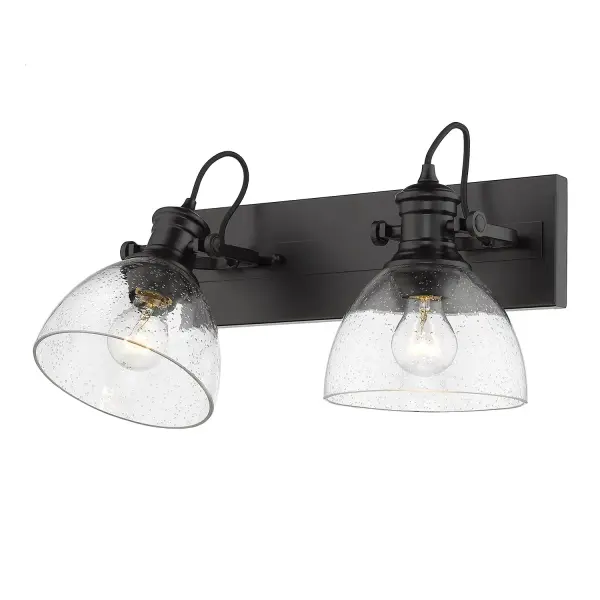 The Hines 2-Light Vanity combines farmhouse charm with contemporary sophistication. Seeded glass shades create warm, textured light while the matte black finish adds modern edge. Adjustable directional heads offer functional flexibility.