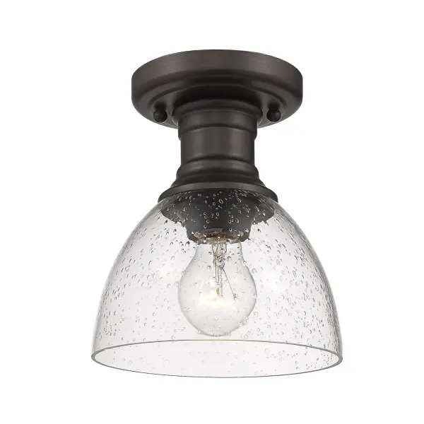 The Hines semi-flush mount delivers authentic vintage character through seeded glass and rubbed bronze finish. Its compact 6.88" profile suits tight spaces while the artisanal glass diffuses light beautifully. Damp-rated for versatility.