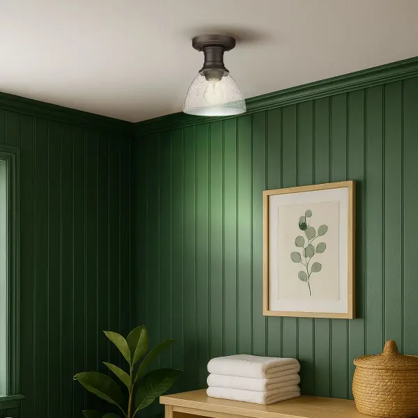 The Hines semi-flush mount delivers authentic vintage character through seeded glass and rubbed bronze finish. Its compact 6.88" profile suits tight spaces while the artisanal glass diffuses light beautifully. Damp-rated for versatility. - alternate view