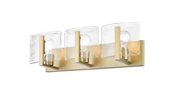 The Aenon 3-light vanity combines artisanal hammered water glass with brushed champagne brass for a sophisticated, nature-inspired aesthetic. Perfect for modern bathrooms seeking both practical illumination and decorative appeal.