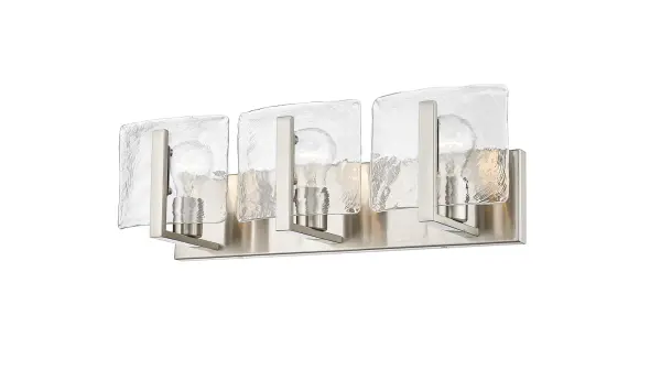 The Aenon 3-Light Vanity combines artisanal hammered water glass with a versatile pewter finish, creating a sophisticated fixture that bridges contemporary and traditional design. Perfect for task lighting with a decorative touch.