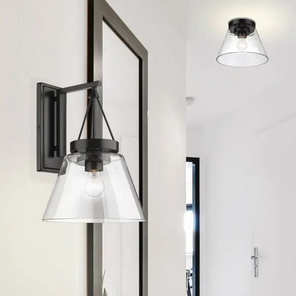 The Penn Wall Sconce delivers clean, contemporary style with its matte black frame and clear glass shade. Perfect for modern homes seeking unobtrusive lighting that enhances rather than dominates a space. - alternate view