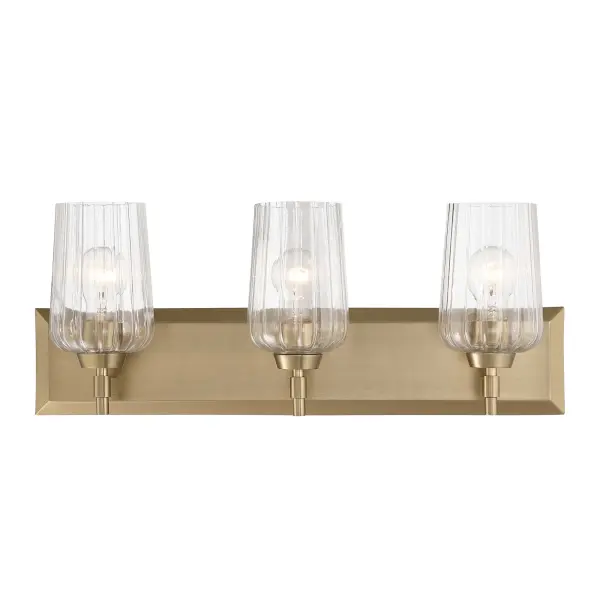 The Yep by Golden Lighting Brilia 3-Light Vanity offers a sophisticated balance of classic form and modern detailing. A clean rectangular backplate and streamlined metal arms provide a structured foundation, while clear fluted glass shades introduce subtle texture and architectural interest. The vertical ribbing gently refracts light, creating a bright, even glow with crisp clarity and visual depth. Finished in Brushed Champagne Brass, the electroplated frame features a soft satin luster with warm, muted gold tones that add understated elegance without overpowering the design. Measuring 24"W x 8.63"H x 6.63"D, this vanity fixture is ideal for bathrooms, powder rooms, and dressing areas where functional task lighting and refined style are equally important. Damp-location rated, it is well suited for covered and moisture-prone spaces and requires three E26 medium-base bulbs (not included). Collection: Brilia Finish: Brushed Champagne Brass Glass: Fluted Glass Width: 24.00" Height: 9.25" Extension from Wall: 6.13" Canopy: 24"W x 4.87"H x 0.75"D Number of Bulbs: 3 Maximum Wattage: 60.00 W Bulb Type: A19 Bulb Base: E26 Dimmable Voltage: 120.00 V Country of Origin: China Safety Listing: ETL Manufacturer Warranty: 1 Year Limited - alternate view