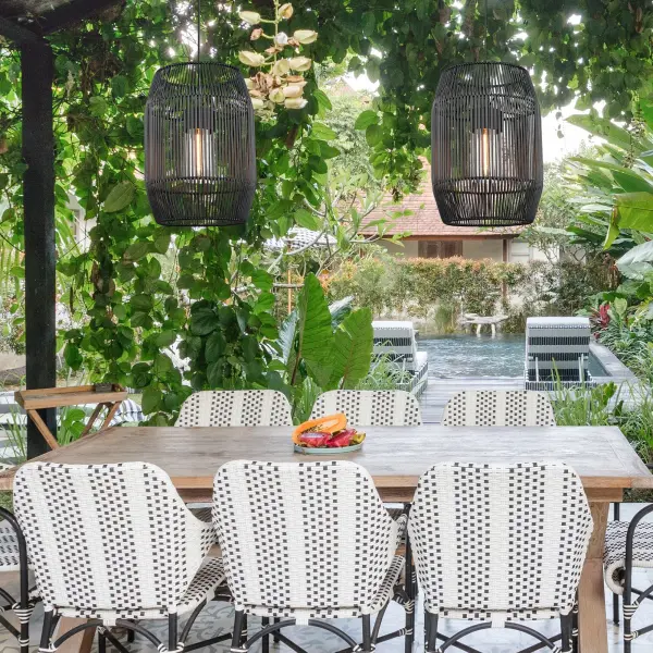 The Seabrooke outdoor pendant combines handcrafted black wicker with a natural black frame for a sophisticated bohemian look. Wet location rated and sloped-ceiling compatible, it's perfect for covered outdoor spaces seeking coastal charm. - alternate view