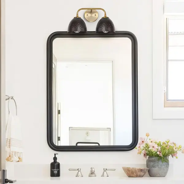 The Shepard 2-Light Vanity combines traditional farmhouse charm with modern industrial elements. Its two-tone finish of Modern Brass and Matte Black creates visual interest while providing practical task lighting for bathrooms and powder rooms. - alternate view