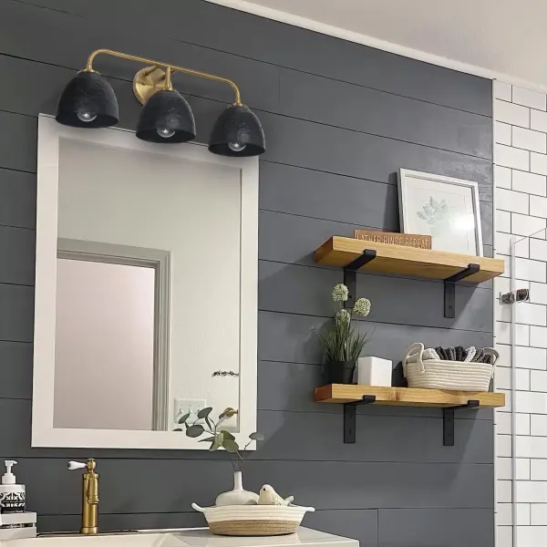 The Shepard 3-Light Vanity combines rustic farmhouse charm with contemporary styling through its two-tone Modern Brass and Matte Black finish. Perfect for bathrooms needing both style and function, this damp-rated fixture provides ample illumination. - alternate view