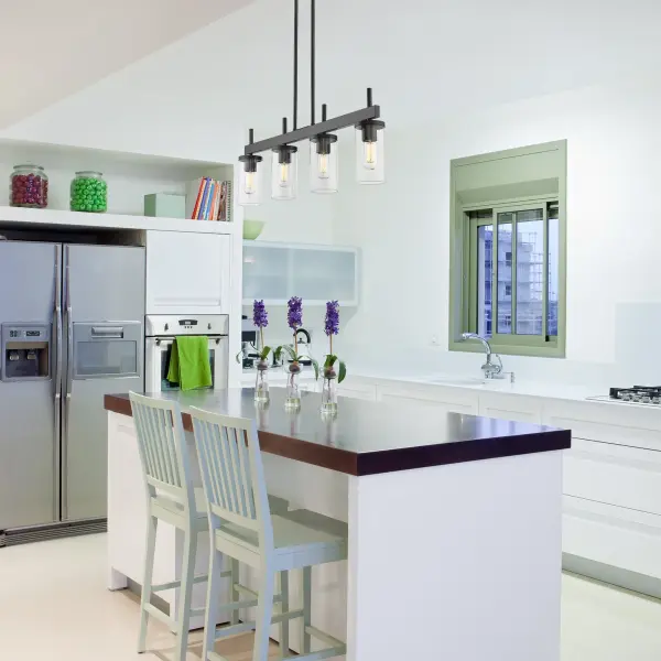 The Winslett 4-Light Island Light combines matte black framing with ribbed clear glass shades to create a versatile fixture that works beautifully in transitional, contemporary, and industrial spaces. Perfect for kitchen islands. - alternate view