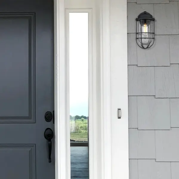 The Seaport outdoor wall sconce brings vintage coastal elegance with its seeded glass shade and matte natural black finish. Wet location rated for direct weather exposure, it's perfect for entryways, patios, and garage doors. - alternate view