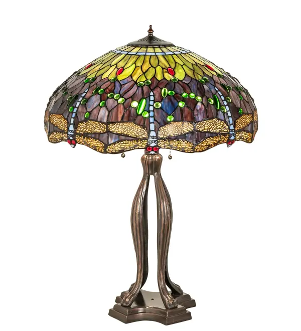 This beloved lighting design is modeled after the original hanging head dragonfly from Tiffany Studios. Diving Blue Dragonflies with glowing Red jeweled eyes and delicate metal filigree wings circle over hand cut and copper foiled pieces of Lakeside Blue and Pond Green glass that represent rippling water. Green and Red jewels accent the background. This lovely shade is created using the famous Meyda Tiffany copperfoil construction and enhanced with a Mahogany Bronze finished lamp base. UL and cUL listed for dry locations. Each shade is a unique work of art with color variations based on natural ingredients inherent in the glass. Contact us if color matching is critical when ordering multiple items.