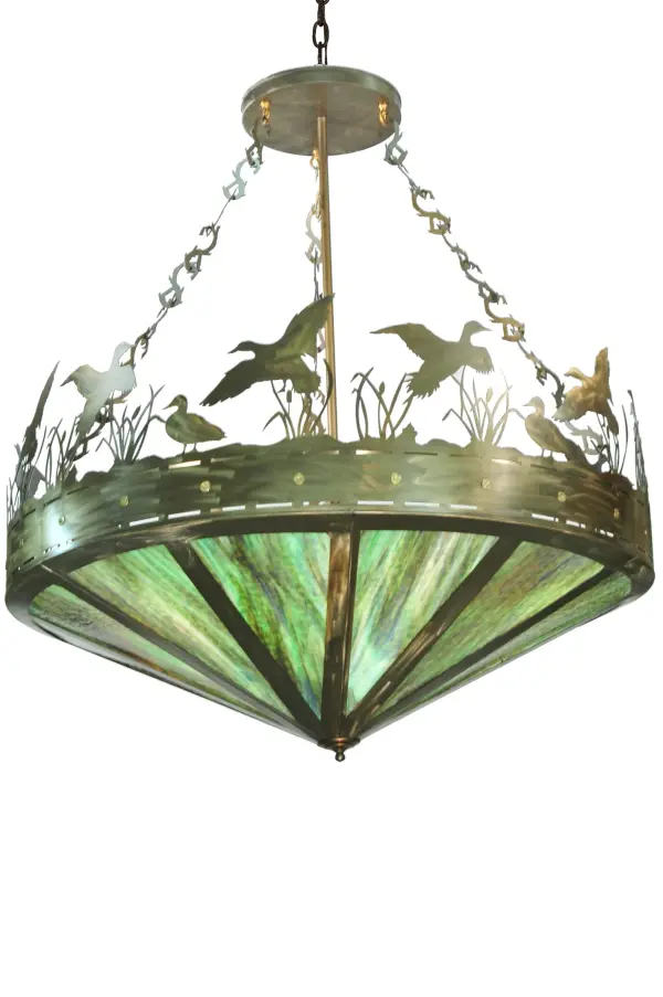 A flock of Ducks in and above cattails and marsh grasses top this wildlife inspired original pendant handcrafted in the USA by Meyda artisans. Suspended from hand crafted branch like chain links the bullet accented band and Ducks top Marsh Grass above Greenish Brown art glass panels. This fixture is finished in Antique Copper.