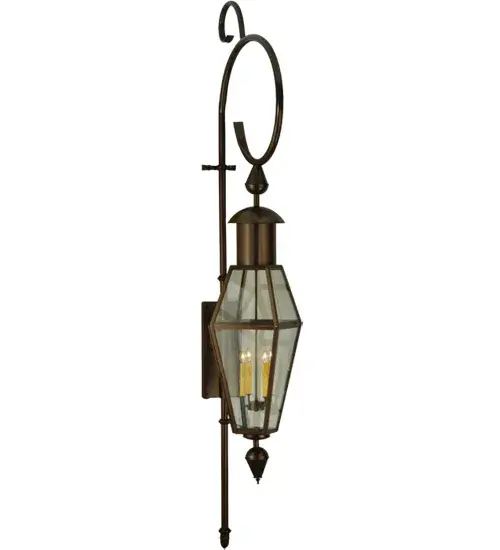 A towering indoor/outdoor wall lantern. This sconce combines traditional elegance with gothic charm. A Clear Glass Lens reveals four Ivory faux candlelights. The fixture is complemented with a Hand-Forged Iron Scrolled element featured in a Timeless Bronze finish. Handcrafted by highly skilled artisans in our 180;000 square foot manufacturing facility in Yorkville; New York. Lantern styles; metal finishes and fixture sizes can be customized to your needs. UL and cUL listed for dry; damp and wet locations. - alternate view