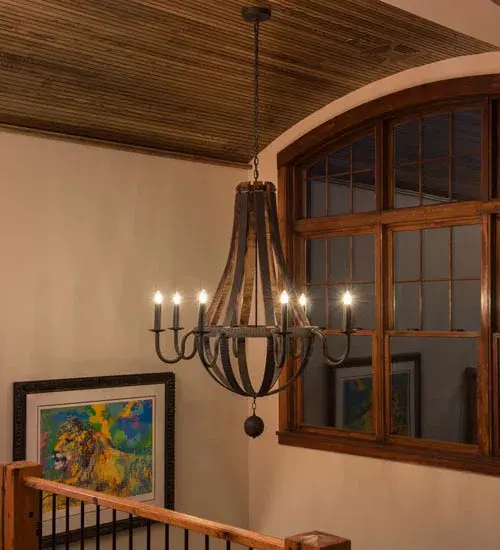 Rugged rustic charm greets Gothic character. This lighting design was inspired by Antique Wooden staves traditionally bound by wooden hoops in the construction of beer/ whiskey barrels and wine casks. Coffee Bean finished solid-stout curved arms support eight bobeches accented with Ivory faux candles on its perimeter and an orb finial below. The overall height of this chandelier ranges from 64 to 112 inches as the chain length can be easily adjusted in the field to accommodate your specific lighting application needs. Handcrafted in our 180;000 square foot manufacturing facility in Yorkville; New York. Candlelight colors; metal finishes and fixture sizes can be customized to your needs. UL and cUL listed for dry and damp locations. - alternate view